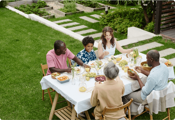 Overhead view of a family sitting outside eating a meal on a mild summer afternoon