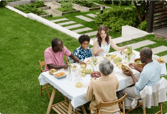Group of young adults eating dinner outside on a calm summer evening